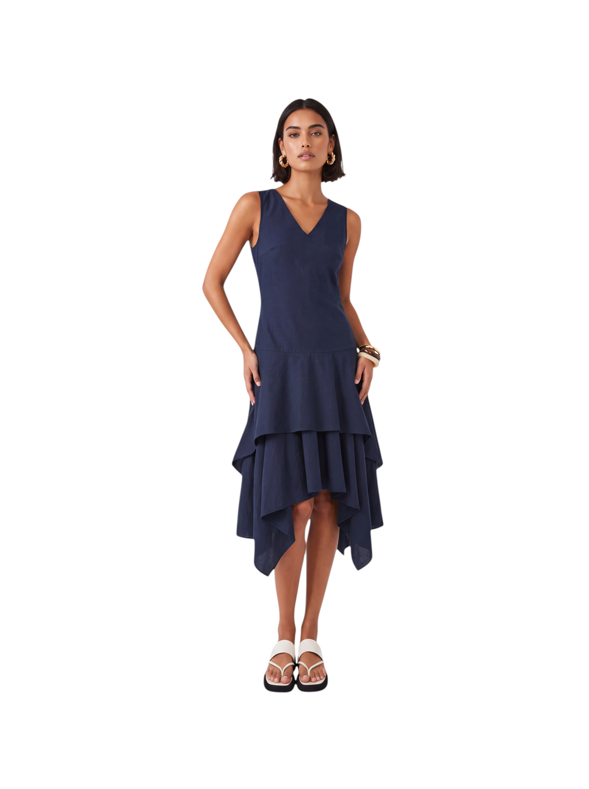 Model wearing a navy sleeveless K/Woods Solstice Dress with a keyhole neckline and double-tiered handkerchief hem.